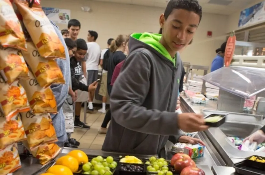 Student looking at fruit in a school lunch line